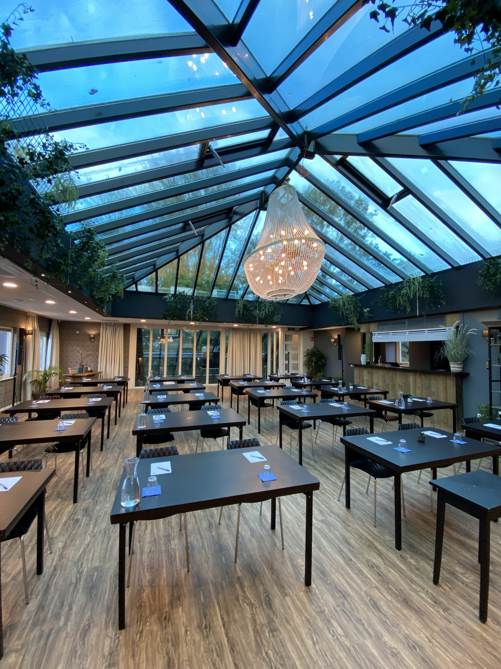 De Beatrixpark zaal in Amstel Boathouse, groot dakraam en bar, planten en groen, tafels, quiz opstelling